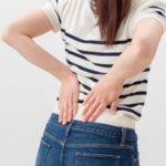 腰を痛がる女性