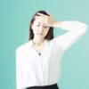 額に手をあてる女性