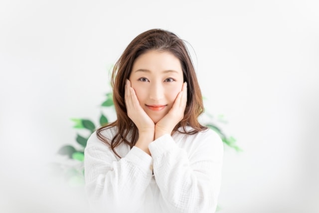 顔に手を当てる女性
