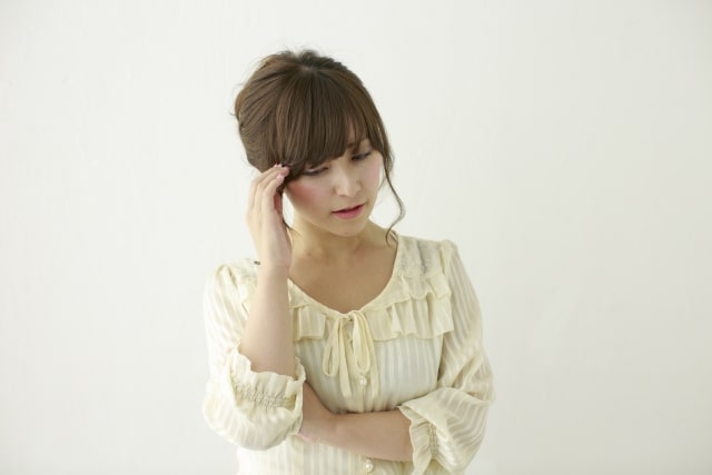 頭を痛がる女性